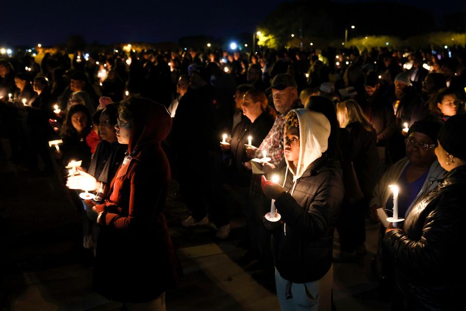 People hold candles as they listen to speakers at a vigil for victims of a shooting at the Chesapeake Walmart Supercenter on November 28, 2022 in Chesapeake, Virginia.