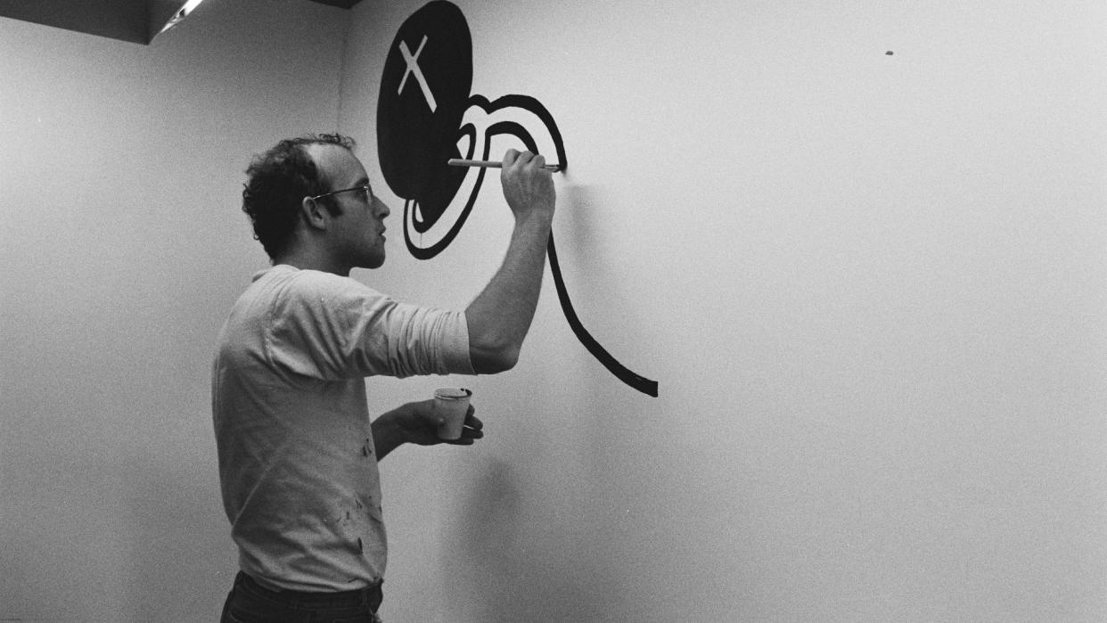 Keith Haring in 1986 painting a mural on a wall