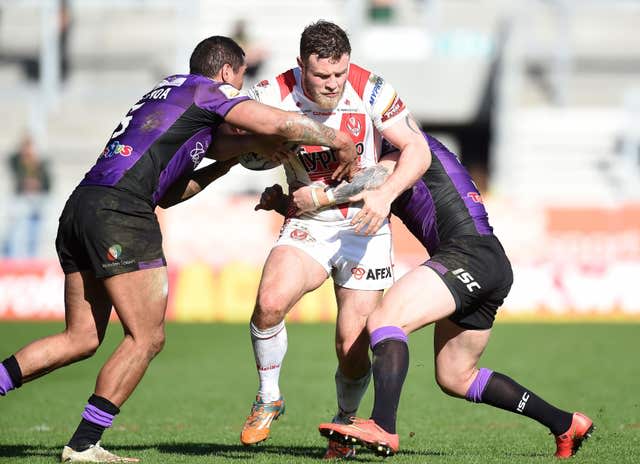 St Helens Josh Jones is tackled by two players during a game against Hull