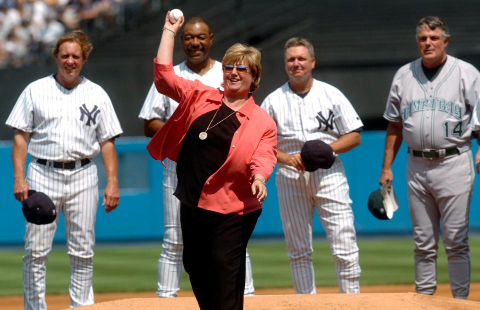 Diana Munson, widow of New York Yankees catcher Thurmon Munson, is surrounded by some of her husband's former teammates as she throws out the ceremonial first pitch during Old Timers' Day festivities Saturday, July 10, 2004 in New York.