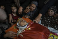 Palestinian mourners gather around the body of Zaid Ghunaim,15, during his funeral in the West Bank town of Al-Khader, Saturday, May 28, 2022. The Palestinian Health Ministry says Israeli forces shot and killed Ghunaim during an operation late Friday near Bethlehem in the occupied West Bank. The army says soldiers opened fire after Palestinians hurled rocks and firebombs at them. (AP Photo/Mahmoud Illean)
