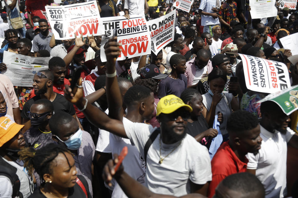 People hold banners as they demonstrate on the street to protest against police brutality in Lagos, Nigeria, Thursday Oct. 15, 2020. Protests against Nigeria's police continued to rock the country for the eighth straight day Thursday as demonstrators marched through the streets of major cities, blocking traffic and disrupting business. (AP Photo/Sunday Alamba)