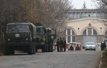 Armed people and military trucks are seen near a checkpoint outside a building in the territory controlled by the self-proclaimed Donetsk People's Republic in Donetsk, eastern Ukraine, November 12, 2014. REUTERS/Maxim Zmeyev