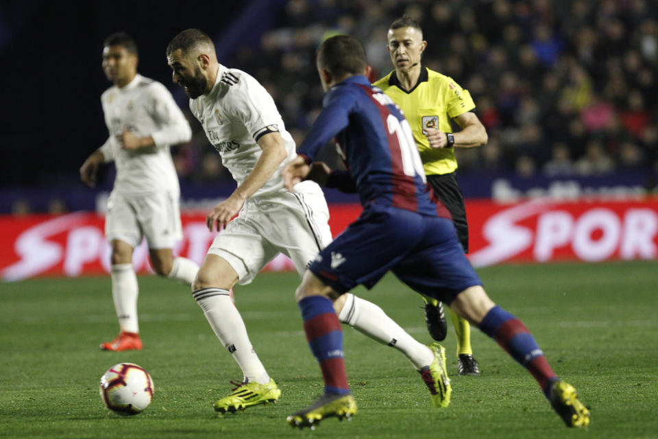 Real forward Karim Benzema, left, runs with the ball past Levante's Jose Luis Morales during a Spanish La Liga soccer match at the Ciutat de Valencia stadium in Valencia, Spain, Sunday, Feb. 24, 2019.(AP Photo/Alberto Saiz)