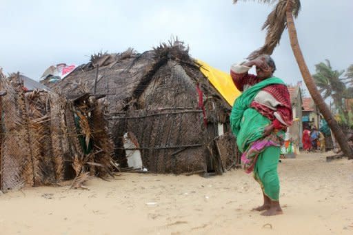 An Indian woman watches as the wind rises in the run up to Cyclone Nilam in Chennai. Thousands of people evacuated from their homes in southeast India Wednesday as a cyclone slammed into the coast, killing two people, according to reports, and causing an oil tanker to run aground