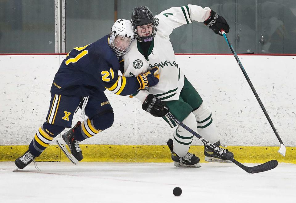Xaverian #21 Michael McGrath and Rams #7 Cam McGettrick battle to each other to get to the loose puck.Marshfield hosted Xaverian in boys hockey at The Bog in Kingston on Thursday February 23, 2023 