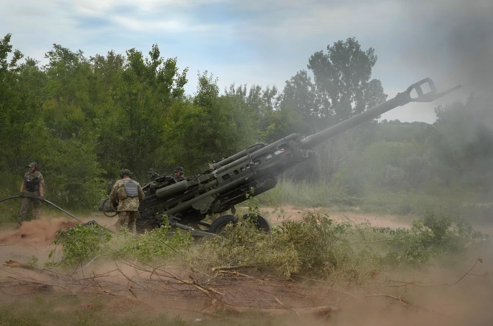 Soldiers fire a M777 Howitzer.