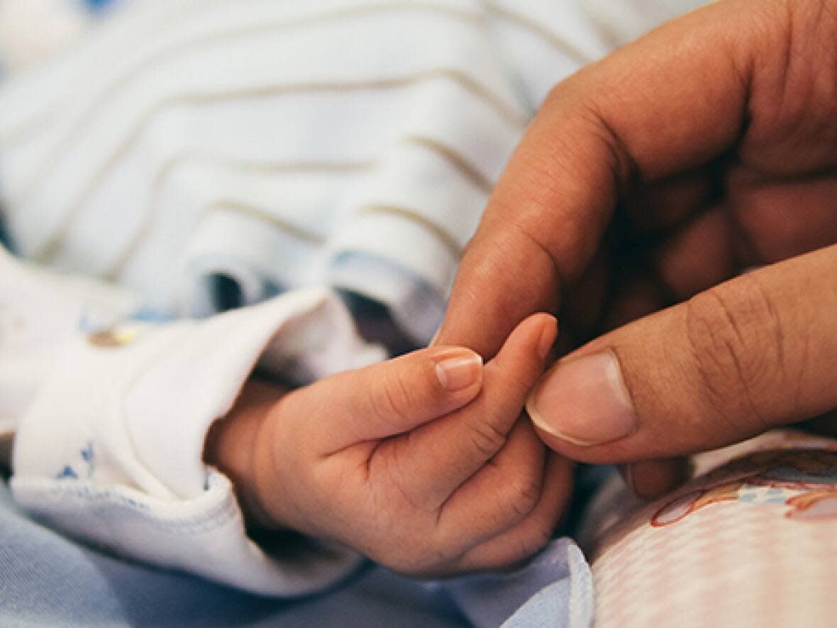 A parent is seen touching a baby's hand in this file photo. The Nova Scotia government says a new family connections co-ordinator will work with expectant parents and families to identify their needs and address barriers to accessing supports and services. (CBC News - image credit)