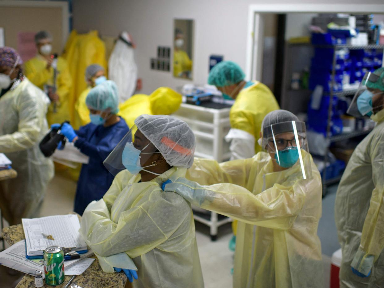 <p>In this file photo taken on 02 July 2020 a healthcare worker gives another a shoulder rub before they go back into the the Covid-19 Unit at United Memorial Medical Center in Houston, Texas</p> ((AFP via Getty Images))