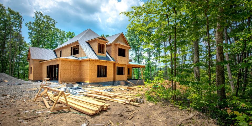 A home under construction surrounded by trees.