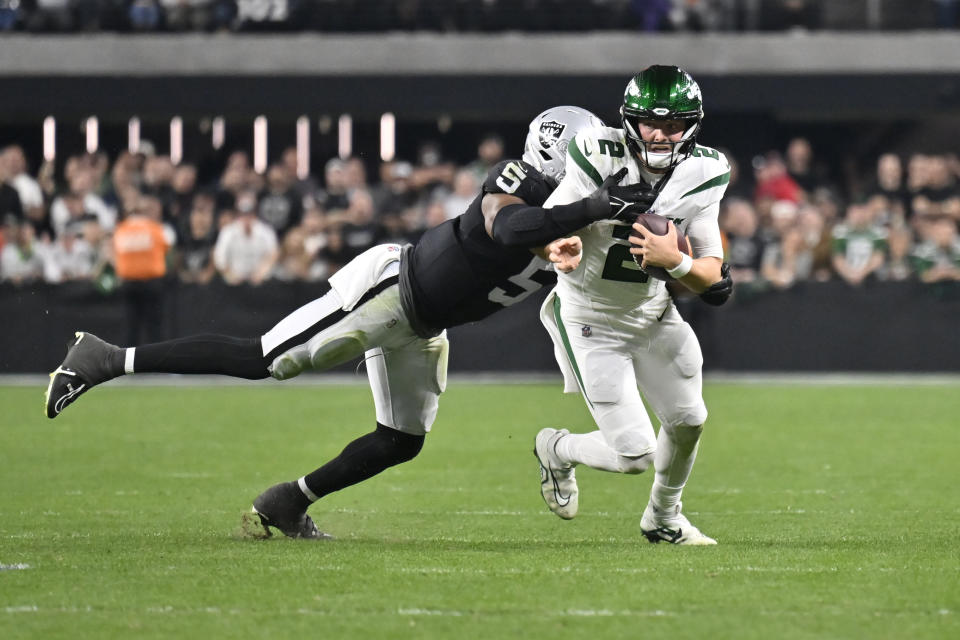 New York Jets quarterback Zach Wilson (2) is tackled by Las Vegas Raiders linebacker Divine Deablo (5) during the second half of an NFL football game Sunday, Nov. 12, 2023, in Las Vegas. (AP Photo/David Becker)