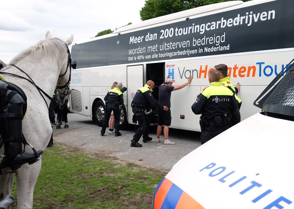 Protesters are voluntarily searched by police, during a demonstration targeting the government’s handling of the coronavirus crisis, at Malieveld, the Hague, Netherlands, Sunday, June 21, 2020. Dutch police charged hundreds of what they called soccer fans with horses and a water cannon in the center of The Hague Sunday and warned people to stay away from the city center. (AP Photo/Michael Corder)