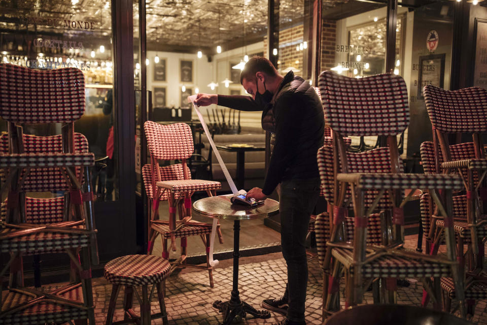 ARCHIVO - En esta imagen de archivo del 17 de octubre de 2020, un camarero comprueba la caja final de la jornada al cerrar un bar con terraza en París. Un rebrote del nuevo coronavirus está asestando un segundo golpe a los restaurantes europeos, que ya sufrieron durante las cuarentenas de primavera. Desde Irlanda del Norte a Holanda, los gobiernos europeos han cerrado los restaurantes o reducido mucho su actividad. (AP Foto/Lewis Joly, File)