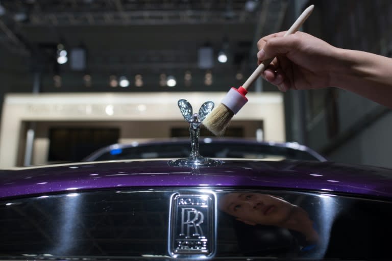 A worker cleans a Rolls Royce car on the eve of the Beijing Auto Show