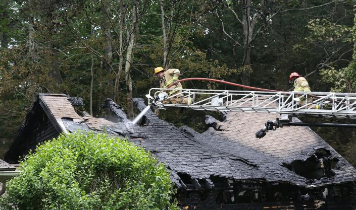 Dover firefighter Jason Nicoll puts water on a garage roof attatched to a home at 38 Watson Road Tuesday, June 28, 2022.