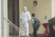 08 July 2020, Rhineland-Palatinate, Koblenz: A resident meets an emergency service person in protective clothing on the stairs to a student dormitory in Koblenz, Germany, Wednesday, July 8, 2020. In three dormitories, residents have contracted Covid-19, others show symptoms. (Thomas Frey/dpa via AP)