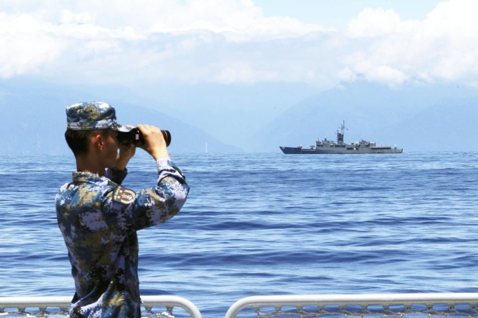 A People’s Liberation Army member watches a Taiwanese frigate during exercises on 5 August in response to the visit by US House Speaker Nancy Pelosi. Lin Jian/Xinhua via AP