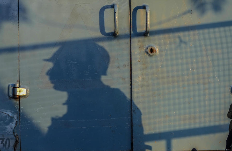 The shadow of an Indian paramilitary soldier is cast on an armored vehicle as he guards at a busy market in Srinagar, Indian controlled Kashmir, Tuesday, Aug 1, 2023. India’s top court Wednesday began hearing a clutch of petitions challenging the constitutionality of the legislation passed by Prime Minister Narendra Modi’s government in 2019 that stripped disputed Jammu and Kashmir’s statehood, scrapped its separate constitution and removed inherited protections on land and jobs. (AP Photo/Mukhtar Khan)