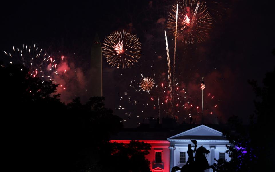 Fireworks explode behind the White House near the Washington Monument on July 4 - Getty