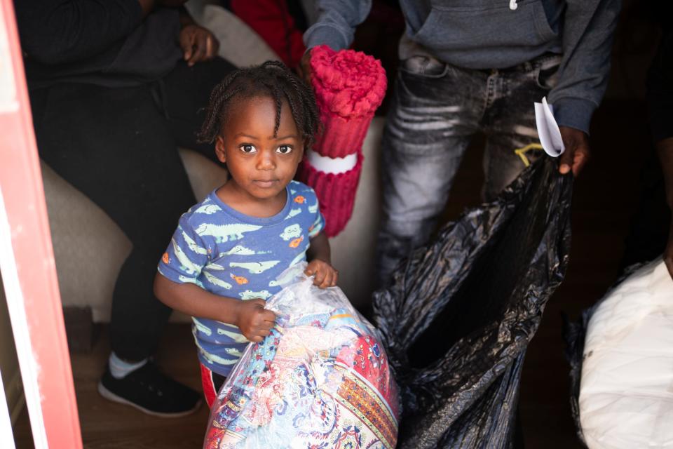Flandy Toussaint, 3, holds blankets given out by CRIS, Haitian Community Network and the city of Columbus, in Colonial Village on the East Side where over 850 Haitian immigrants were scammed into moving into mostly abandoned apartments.