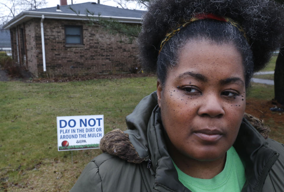 In this Thursday, March 30, 2017, photo, Tara Adams poses for a portrait outside her home as she tries to organize a move from the East Chicago, Ind., dwelling. Adams is one of dozens of families remaining at a lead-contaminated public housing complex in northwest Indiana, despite a Friday target date to move them out so the city can tear down the buildings. (AP Photo/Charles Rex Arbogast)