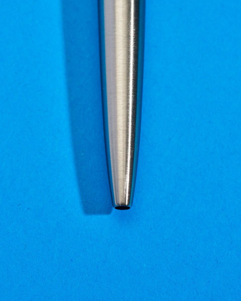 a silver pen on a blue surface