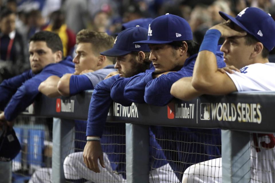 Dodgers players Austin Barnes, Yu Darvish, Clayton Kershaw and Kike Hernandez watch the Astros celebrate.