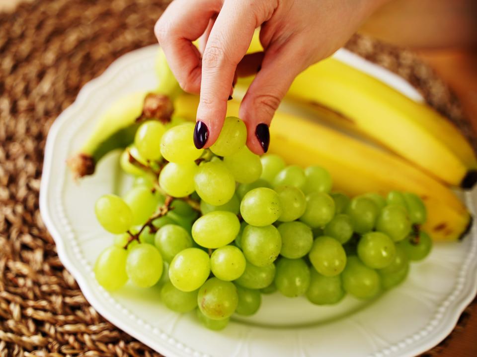 green grapes and bananas on a plate on a tray