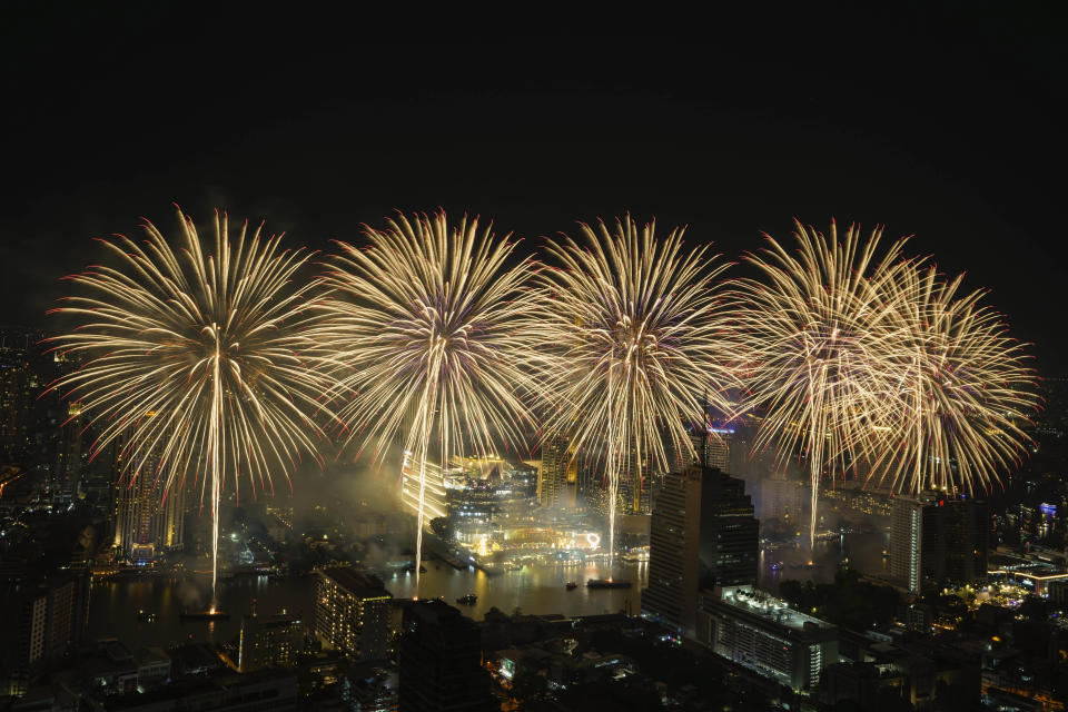 Fireworks explode over the Chao Phraya River during New Year celebrations in Bangkok, Thailand, Sunday, Jan. 1, 2023. (AP Photo/Sakchai Lalit)