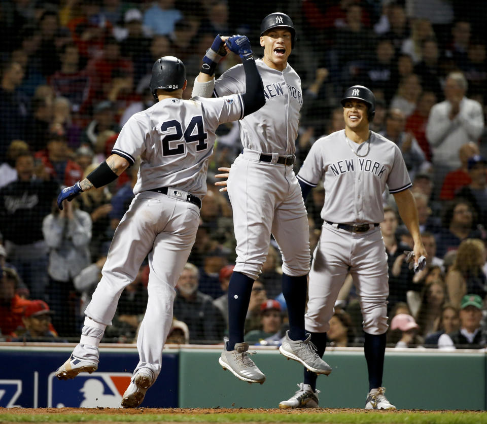 New York Yankees' Gary Sanchez, left, celebrates after his three-run home run against the Boston Red Sox with Aaron Judge and Giancarlo Stanton during the seventh inning of Game 2 of a baseball American League Division Series, Saturday, Oct. 6, 2018, in Boston. (AP Photo/Elise Amendola)