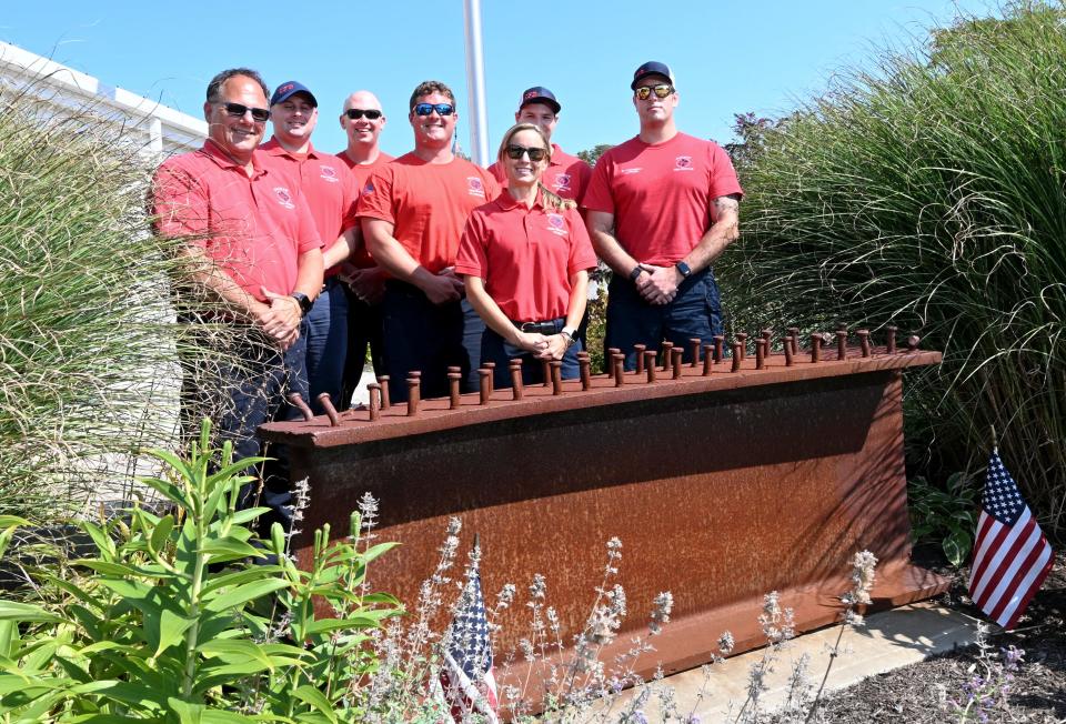 Chatham Fire Chief David DePasquale, left, with members of his department stand behind the 911 memorial in front of the station in Chatham center. From left, are  DePasquale, Dustan McGlinn, Ryan Holmes, Nick Ruggiere, Kristen Taylor, Scott Devlin, and Michael Lopriore. The piece of metal was from the World Trade Center.