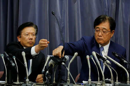 Mitsubishi Motors Corp Chairman of the Board and CEO Osamu Masuko (R) passes a microphone to President Tetsuro Aikawa during a news conference in Tokyo, Japan, May 11, 2016. REUTERS/Toru Hanai