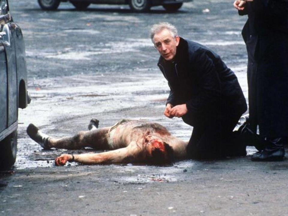 Father Alec Reid giving last rites to one of the two soldiers killed by a mob at the funeral of an IRA member shot by loyalist gunman Michael Stone (Rex)