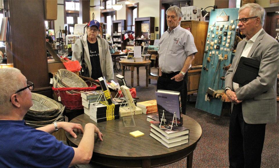 Author Jeff Guinn pauses his book signing to talk to, from left, Janis Test, Texas Star Trading Co. owner Glenn Dromgoole and First Central Presbyterian minister Cliff Stewart. Guinn offered his thought on the 1993 tragedy near Waco, where the Branch Davidian compound was set on fire and almost 80 people died.