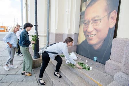 People place flowers and light candles in front a picture of late Nobel Peace Laureate Liu Xiaobo outside the Nobel Peace Center in Oslo, Norway July 13, 2017. NTB Scanpix/Audun Braastad via REUTERS