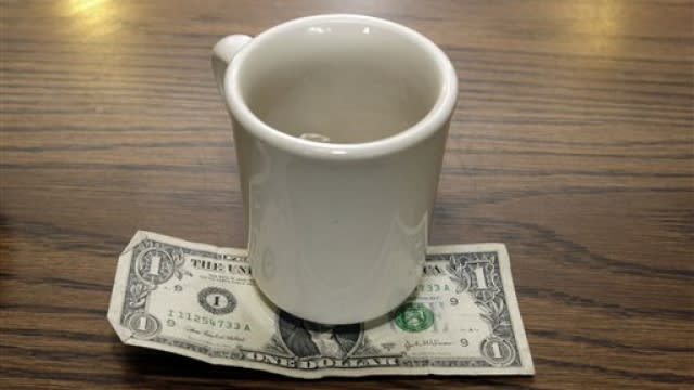 A tip is left under a coffee mug.