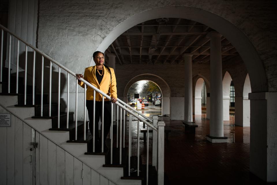 Vanessa Moore, a descendant of lynching victim Archie Beebe, stands on the stairway under the Market House in Fayetteville, N.C.