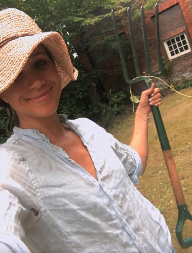 Meghan Markle poses with a hoe in the yard of Nottingham Cottage