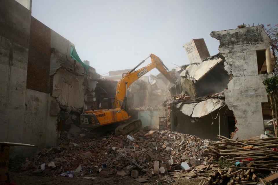 A bulldozer demolishes the house of a Muslim man in Uttar Pradesh (Reuters)