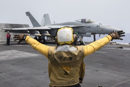 A U.S. Navy crewman directs an F/A-18E Super Hornet fighter jet on the flight deck of the aircraft carrier USS Harry S. Truman in the Mediterranean Sea. U.S. Navy/Mass Communication Specialist 3rd Class Anthony Flynn