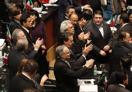 Senators of the ruling Institutional Revolutionary Party (PRI) applaud after Mexico's Senate signed off on an energy bill at the Senate building in Mexico City December 11, 2013. REUTERS/Henry Romero