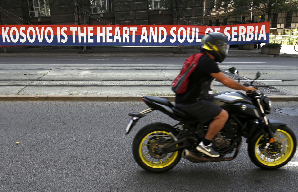 A motorcyclist rides past a billboard reading: ''Kosovo is the heart and soul of Serbia'' placed on a street in front of the government building in Belgrade, Serbia, Wednesday, Sept. 2, 2020. Serbian President Aleksandar Vucic and Kosovo Prime Minister Avdullah Hoti will meet at the White House on Thursday and Friday. (AP Photo/Darko Vojinovic)