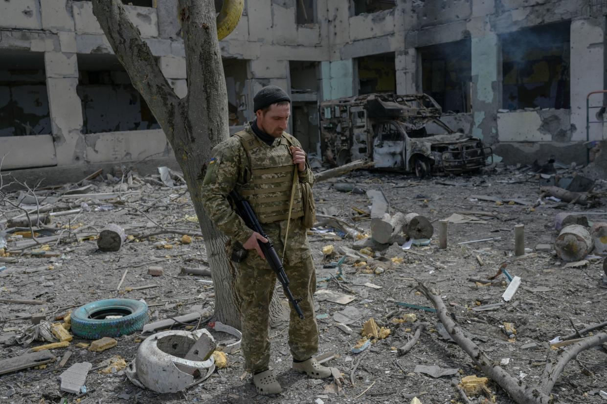 A Ukranien soldier stands outside a school hit by Russian rockets in the southern Ukraine village of Zelenyi Hai between Kherson and Mykolaiv, less than 5km from the front line on April 1, 2022, as NATO says it is not seeing a pull-back of Russian forces in Ukraine and expects 