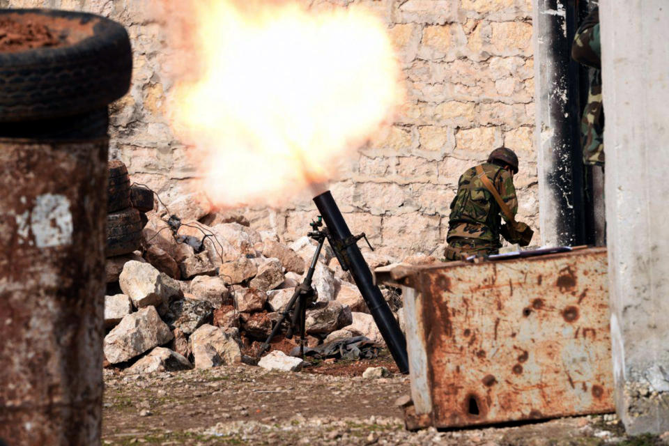 This Monday, Jan. 27, 2020, photo, released by the Syrian official news agency SANA, a Syrian army soldier launches a mortar round toward insurgents on the western rural Aleppo, Syria. Syrian government forces pressed in their offensive Tuesday, Jan. 28, 2020, closing in on a major rebel stronghold in the northwestern province of Idlib and marching against insurgents west of Aleppo, Syria's largest city, state media and opposition activists said Tuesday. (SANA via AP)