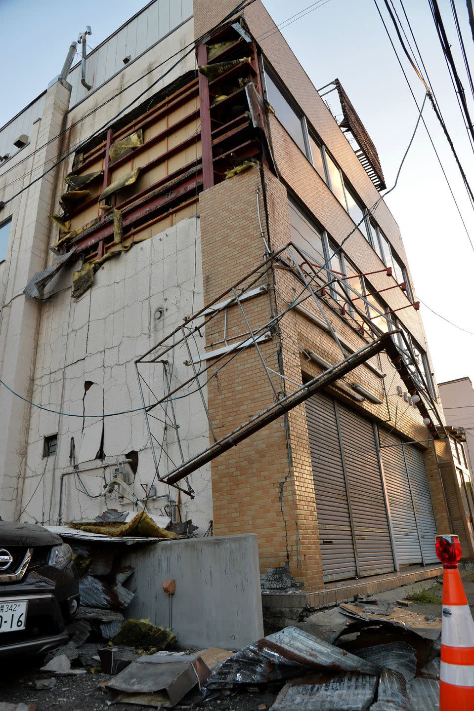 <p>Wires and debris hang from a building in Sapporo, Hokkaido prefecture.</p>