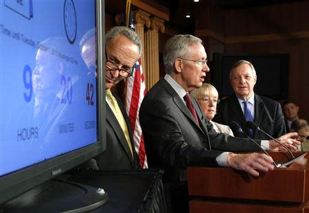 Schumer, Reid, Murray and Durbin stand with a clock counting down to a government shutdown at a news conference at the U.S. Capitol in Washington