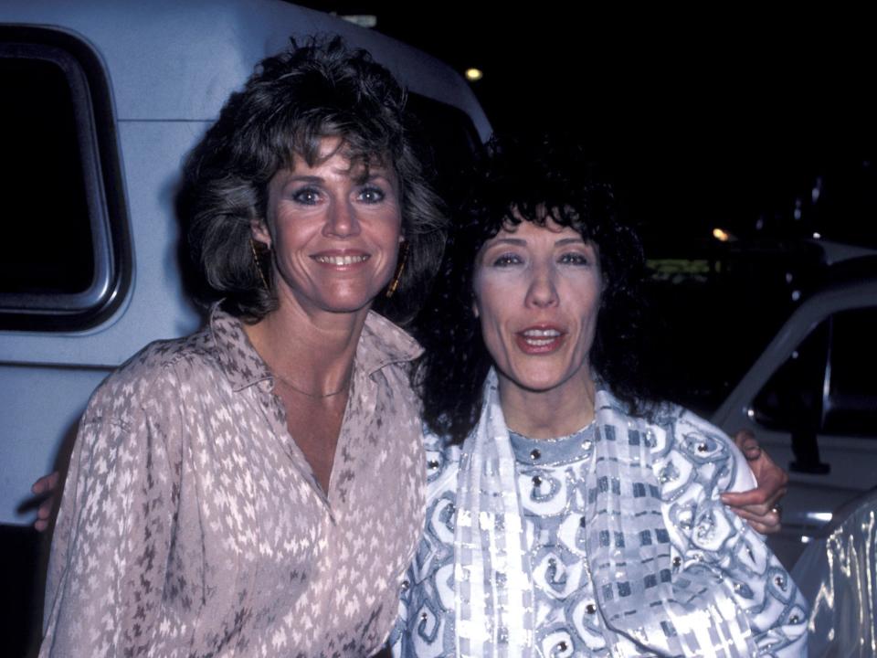 Jane hugging Lily and both smiling in iridescent blouses.