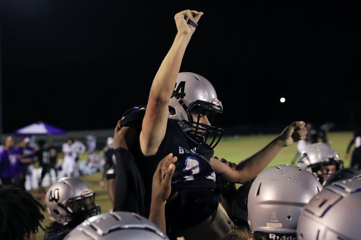 First Coast's Lennoris Linder (34) is celebrated for his game-winning point after the game of a high school football matchup Thursday, Oct. 26, 2023 at First Coast High School in Jacksonville, Fla. The First Coast Buccaneers edged the Fletcher Senators 28-27 on a point after try in overtime to capture the FHSAA District 1-3M title. [Corey Perrine/Florida Times-Union]