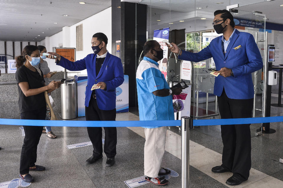 Staff at the National Heart Institute screen visitors upon entry. — Picture by Miera Zulyana