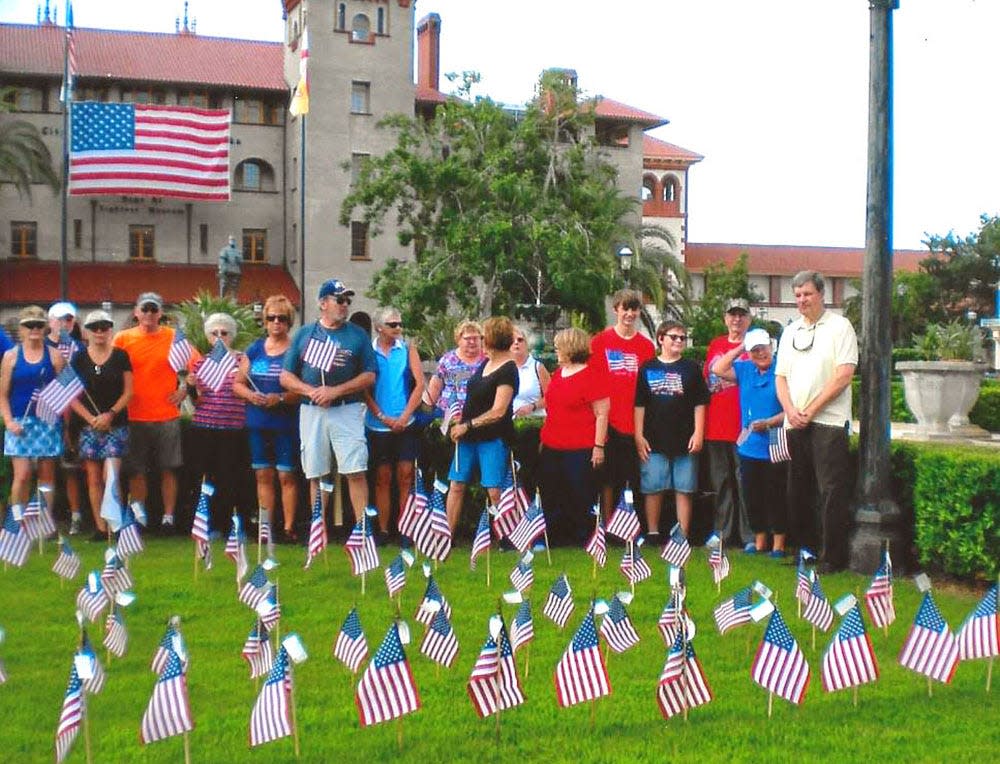 Pilot Club volunteers placing flags on the grounds in front of the Lightner Museum in 2020.